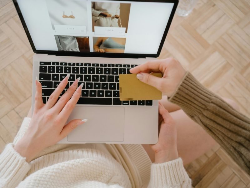 Person shopping online using a laptop and credit card, highlighting e-commerce convenience.